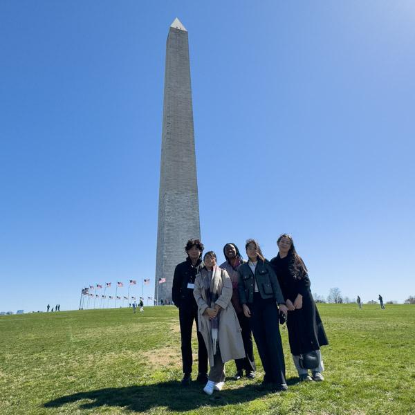 A group of students poses with the Washington Monument in the background.