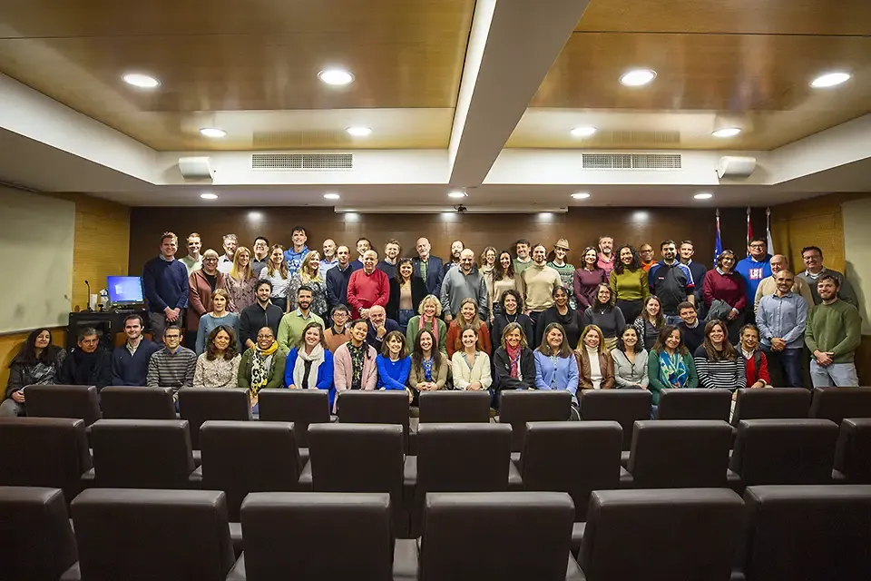 Members of the 博彩网址大全-Madrid Staff standing and sitting in several rows in an auditorium.